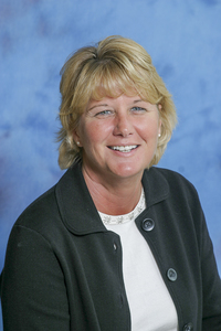 Peggy Levato photographed in front of a blue backdrop. 