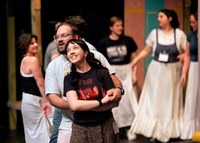 Two actors dance together on stage.