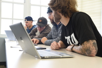 Students in UIU classroom looking at computers.