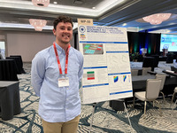 Student standing to left of research poster