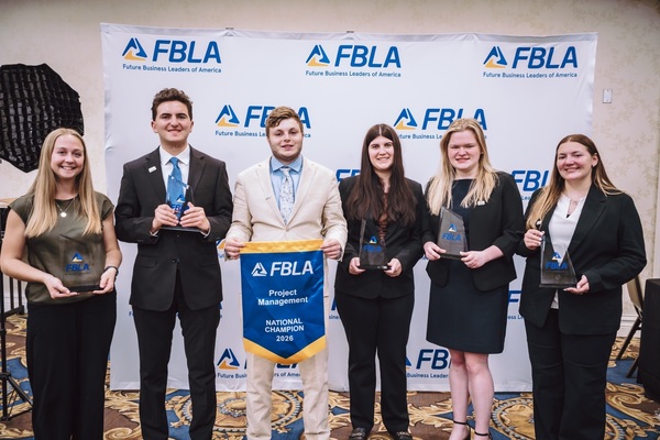 Six students hold awards and stand in front of a backdrop at the FBLA National Conference.