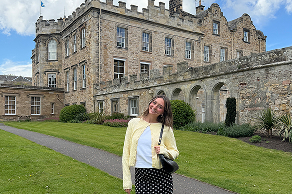 Woman standing in front of a castle. 