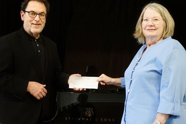 Keith DeFoor, YHC’s Executive Director for Accreditation, Assessment, and Friends Of The Arts, accepts a donation from Jill Long, president of the Board for the Institute for Continuous Learning.