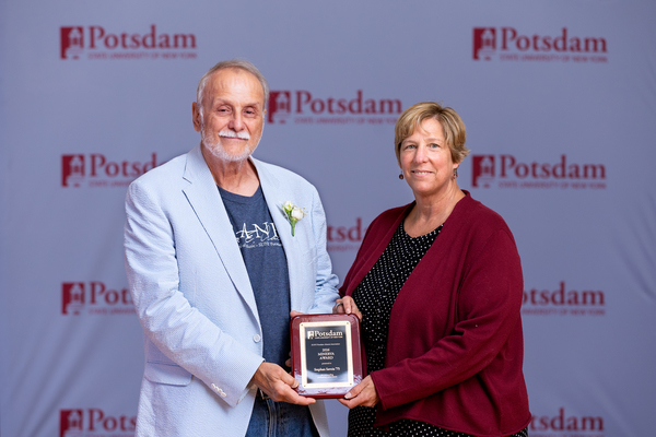 Stephan Savoia ’75 of Pembroke, Mass., is the recipient of the 2026 Minerva Award from the SUNY Potsdam Alumni Association. He is seen here accepting the honor from SUNY Potsdam President Dr. Suzanne R. Smith at Reunion 2026.