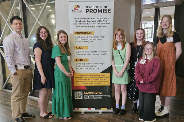 2026 Teachers of Promise from McDaniel College stand around a "Teachers of Promise" sign, smiling for a picture.