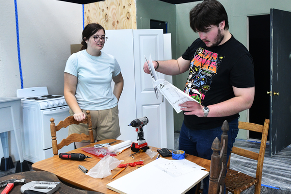 Lindsey Wilson University students McKenzie Melton ’29 of Lily, Kentucky, and Brandon Grider ’28 Columbia consult instructions for assembling a cabinet on the set of “Crimes of the Heart” on Monday, July 13, in V.P. Henry Auditorium. Beth Henley’s award-winning play will be presented at 7 p.m. CT July 30-31 and at 2 p.m. CT Aug. 2 in V.P. Henry Auditorium.