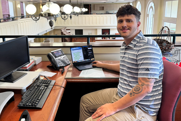 Student Connor Vickers works at his desk during an internship with the Admissions Office at PennWest California. 