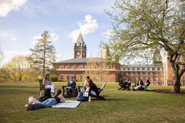 Students reading outside and lounging in the sun on the campus of College of the Holy Cross in the spring
