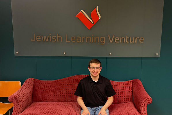 Andrew Walters sits on a couch at Jewish Learning Venture.