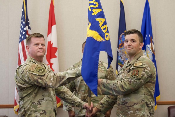Maj. Devin J. Will,  right, a resident of Remsen, accepts the 224th Security Forces Squadron guidon from Col. Joseph J. Miller Jr., 224th Air Defense Group commander, during an assumption of command ceremony on July 27 at the Eastern Air Defense Sector in Rome, New York. The guidon exchange serves as the ceremony’s centerpiece and symbolizes the passing of command to a new commander. 