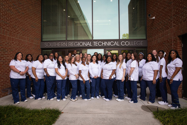 ASN Graduates pose outside brick building