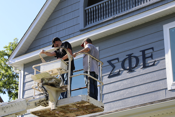 LETTERMEN: These workers make their way back to the ground after installing the Greek letters at the new home of Sigma Phi Epsilon.