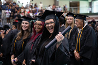 SRTC graduates in black graduation caps and gowns, holding their diploma tubes.