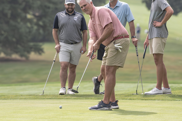 From left, Max DiCicco, a 2021 finance graduate from Trine University, Scott Gruner, a 1998 accounting graduate, and Max Gruner watch as Lance Krebs putts at the university’s 36th annual Alumni and Friends Golf Outing on Aug. 7. The event raised a record $115,000. (Photo by Dean Orewiler / Trine University)