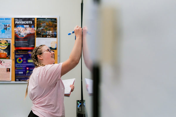 Natalie Preble writes on a whiteboard.