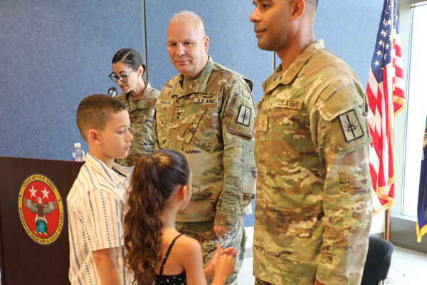 New York Army National Guard Major Jorge Medina prepares to receive his new rank from his daughter Callie during promotion ceremonies at New York National Guard headquarters in Latham on August 13, 2026 as his son Jaxson and Major General Ray Shields, the adjutant general of New York, look on.