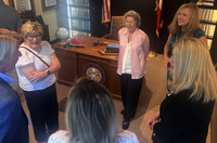Guests visit around the replica legislative desk during the dedication of the William “Billy” McCoy Mississippi Heritage Room.