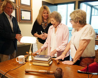 Members of the McCoy family examine books, gavels and other memorabilia arranged on the heritage room’s replica legislative desk.