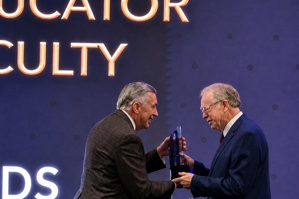 Dr. Michael L. Baker, president of the Pentecostal Theological Seminary (left), presents Dr. Terry L. Cross with the Distinguished Educator Award for Faculty during the Church of God General Assembly in July. 
