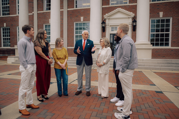 Troy University students talking on campus to Troy University's Chancellor, Dr. Jack Hawkins Jr. 