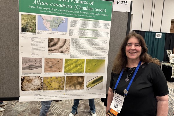 Dr. Nina Baghai-Riding displaying the poster, "A Preliminary Anatomical Study of Allium canadense," produced by her Spring 2026 Plant Anatomy (BIO 410) class.
