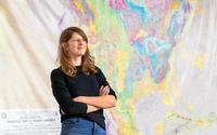 Page Quinton stands in front of a geologic map.