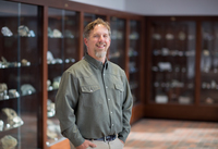 Michael Rygel poses in the Geology Museum at SUNY Potsdam.