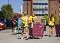 Students wearing "Welcome Team" shirts help freshmen move in to residence halls at SUNY Potsdam.