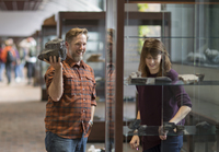 Michael Rygel holds a rock specimen while Page Quinton looks at items in the Geology Museum at SUNY Potsdam.