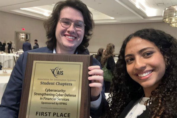 students stand together holding first place plaque. 