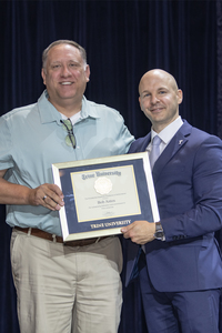 Bob Antos receiving framed certificate from Dr. Tony Kline