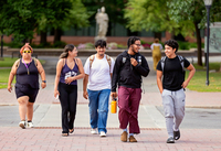 Students talk as they walk across campus.