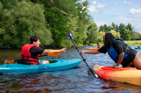 Students laugh while kayaking in the river.