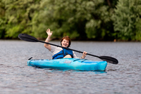 Students laugh while kayaking in the river.