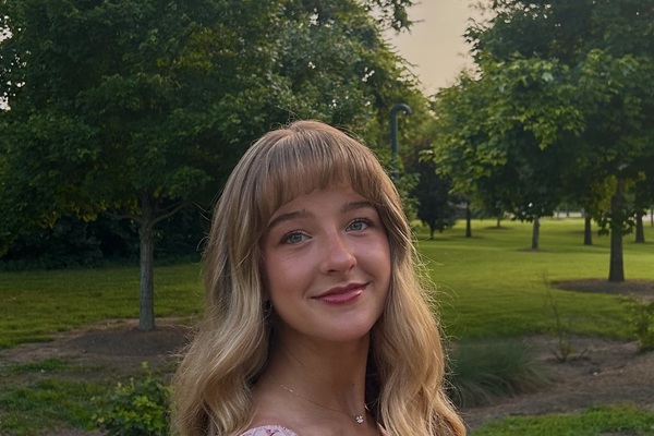 woman in field of trees smiling