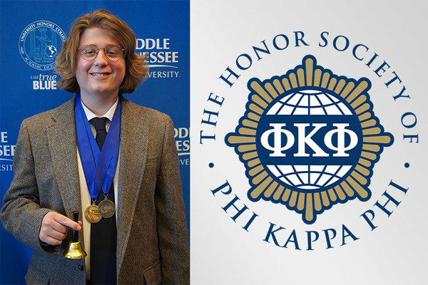 man wearing two medals in a suit jacket holding a small bell and smiling
