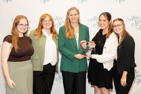 Jamie Jones Miller, center, Alpha Sigma Tau’s national president, presents an award to Epsilon Kappa Chapter officers, from left, Daveena Moyer, Eileen Dollar, Cadence Bommarito and Brooke Shelburne.