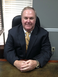 Portrait of Dr. William "Bill" G. Jackson sitting at a conference room table