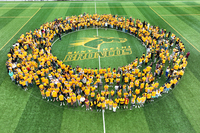 An aerial photo of SUNY Delhi's Fall 2026 incoming class standing in a circle on the athletic field on campus.