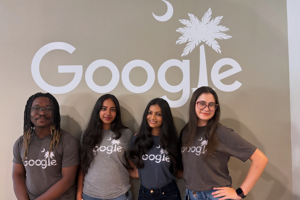 Students standing underneath the Google logo at the data center. 