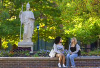 Students talk while sitting in Minerva Plaza at SUNY Potsdam.