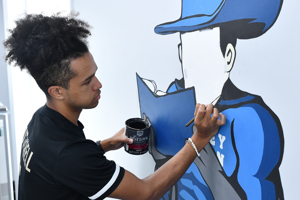 Lindsey Wilson University student Tezon Mitchell ’27 works on the six-foot tall Blue Raider Bob mural on the top floor of the T.D. and Rowena Everett Building, which houses the university’s Student Success Center.