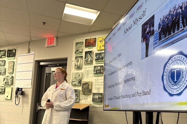 Student standing to left of screen with "About Myself" slide.