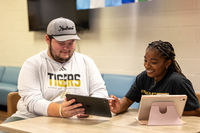 NEMCC students look over an iPad