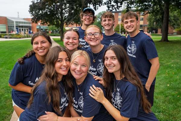 Students in navy tshirts pose for a photo on move-in day.