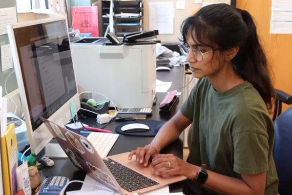 student sits at computer in research lab
