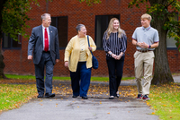 Lance Evans and Cheryl Evans walk with two student scholarship recipients across the SUNY Potsdam campus.