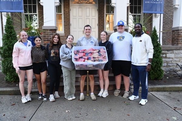 Nine Lindsey Wilson University students spent part of their Sept. 10 evening planting U.S. flags alongside central sidewalks of the A.P. White Campus to honor the victims of 9/11. From left: business graduate student Kyra Engel of Langgons, Germany; Trina Nguyen '30 of Columbia; Adelyn Bennett '29 of Columbia; Brinkley Todd '28 of Louisville, Kentucky; Braxton Crook '27 of Lebanon, Tennessee; Ryan Burkett '30 of Shepherdsville, Kentucky; Brayden Irvin '30 of Windsor, Kentucky; and Michael Wood '30 of Charleston, Tennessee. Not pictured: Mynor Chic '29 of Russell Springs, Kentucky.