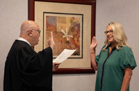 Judge Mark Mitchell (left) swears in Tonya Brown (right), both raising their right hands, as Judge Mitchell reads off a piece of paper.