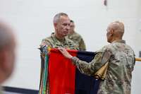 Two people unfurling military flag on Sept. 11, 2026.